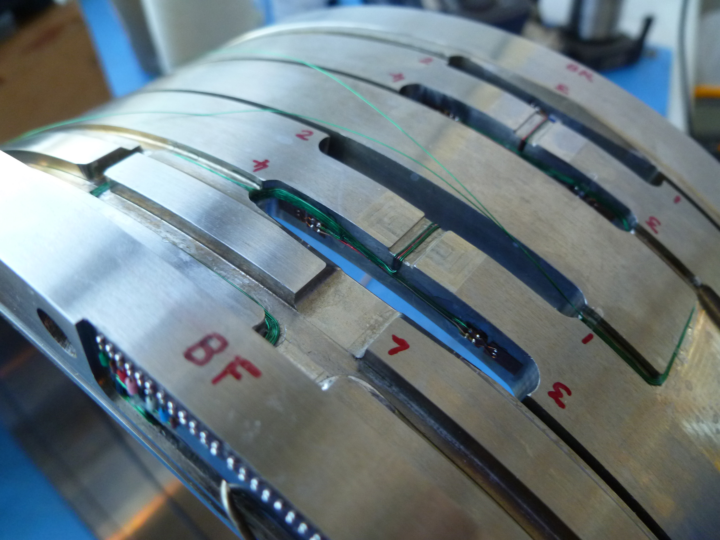 Bespoke wind tunnel balance. Complex cylindrical shell structure with flexures created with machined slots. Strain gauges, wiring and connection tag boards shown in the process of being installed.